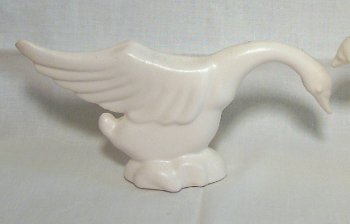 White geese posing, one with head down, one with head and wings up by Haeger Pottery.