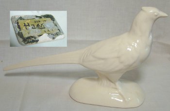 White pheasant with tail outstretched. Sticker on bottom reads "Genuine Haeger Pottery".