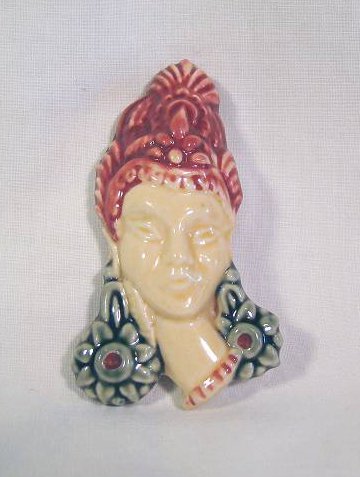 Pale Cleopatra-like head and neck piece with red hair and earrings, pottery jewelry.